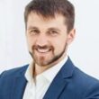 The smiling male office worker against white office